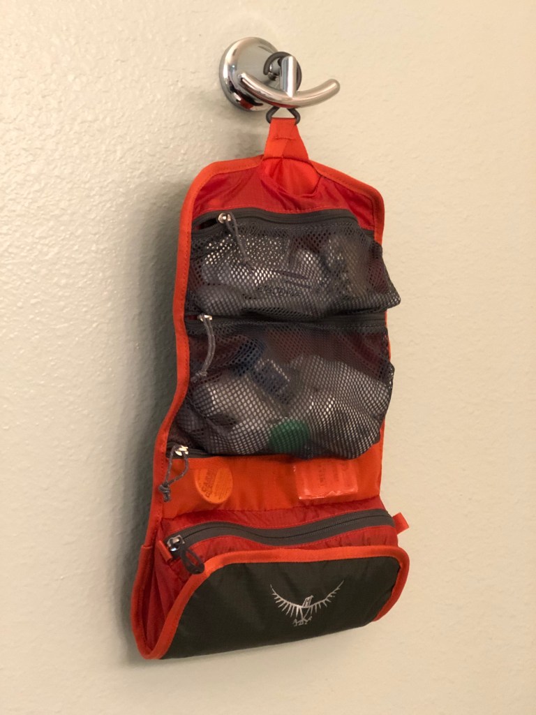 Osprey toiletry bag hanging on a hook.